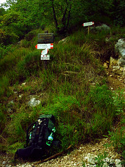 Wanderweg 404 am Gardasee. eine Weggabelung und ein abgestellter Wanderrucksack.